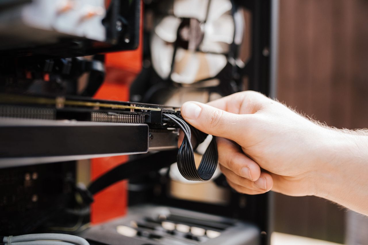 Mani di un tecnico che collegano i cavi durante la sostituzione dell'hardware di una postazione